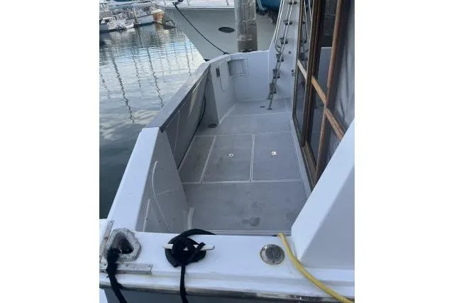 Slide: The Image of 1988 Kadey Krogen 42 boat deck, docked at marina, showing clean, spacious layout. - 16