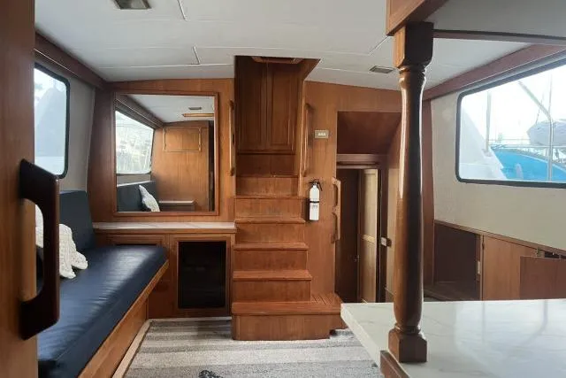 Slide: The Image of 1988 Kadey Krogen 42 interior with wooden finish, staircase, and seating area. - 2