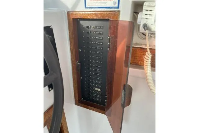 Slide: The Image of Electrical panel on 1988 Kadey Krogen 42 boat, featuring switches and a wooden frame. - 26