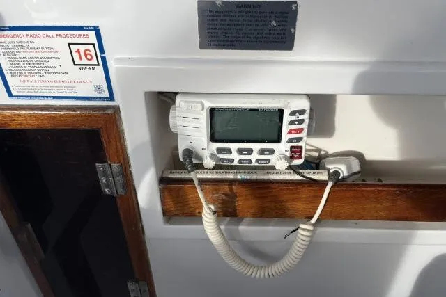 Slide: The Image of VHF radio on 1988 Kadey Krogen 42 boat, with emergency call procedures displayed. - 27