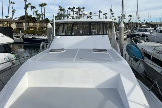 Slide: The Image of 1988 Kadey Krogen 42 yacht docked in a marina, surrounded by sailboats and palm trees. - 30