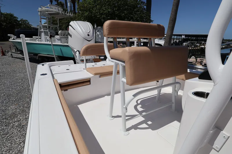 Slide: The Image of 2026 Contender 26 Bay boat with tan seating and white deck in marina setting. - 23
