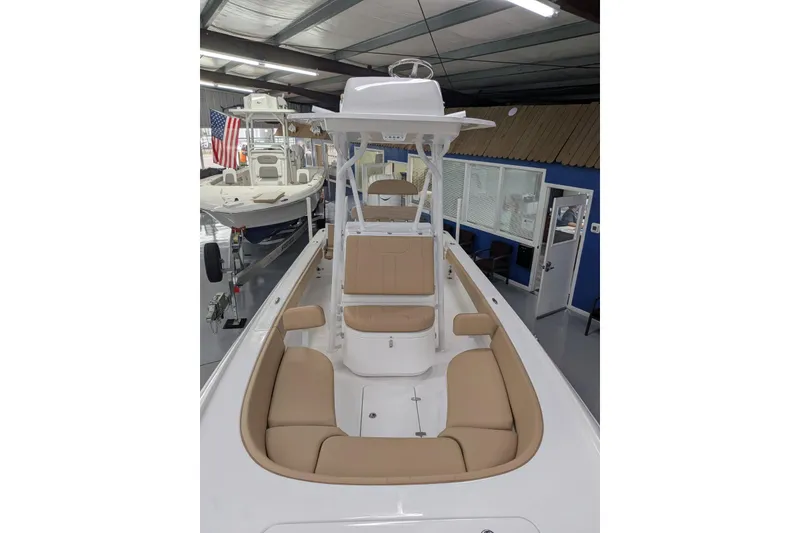 Slide: The Image of 2026 Contender 26 Bay boat interior with tan seating, displayed indoors. - 25