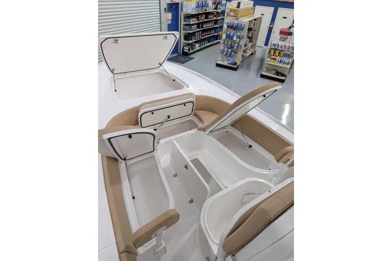 Slide: The Image of 2026 Contender 26 Bay boat interior with open storage compartments in a showroom. - 26