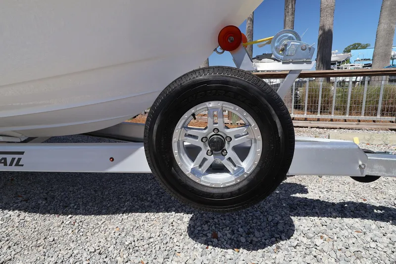 Slide: The Image of Trailer wheel of a 2026 Contender 26 Bay boat on gravel surface. - 30