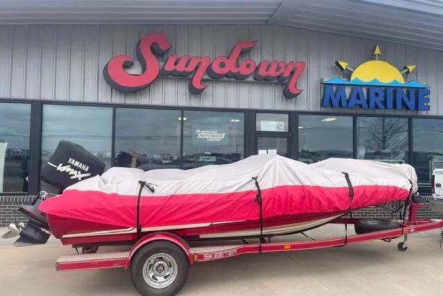 Slide: The Image of 2003 Skeeter SL 190 boat on trailer outside Sundown Marine store. - 2