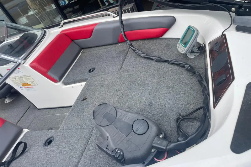 Slide: The Image of 2003 Skeeter SL 190 boat interior with red and gray seating, carpeted deck, and control panel. - 8
