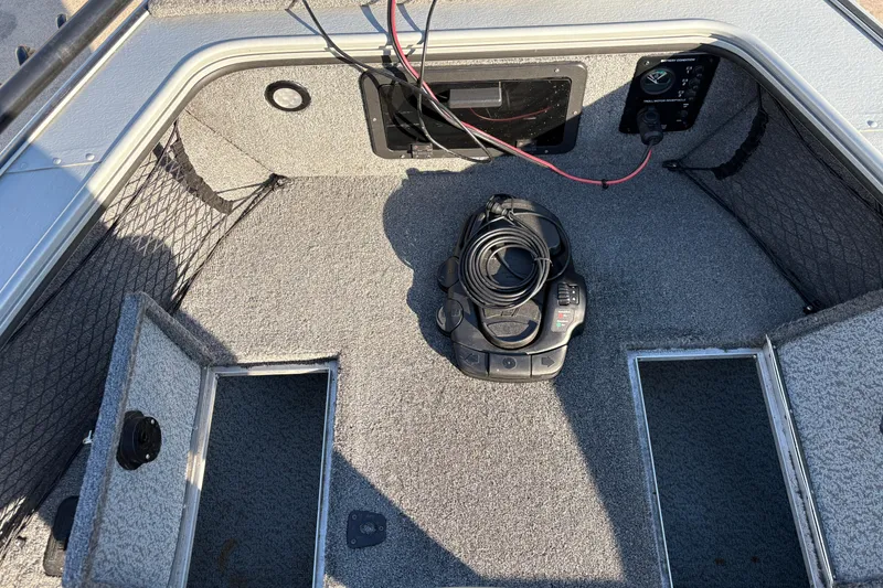 Slide: The Image of 2005 Lund 2025 Pro-V LE boat interior with storage compartments and control panel. - 11