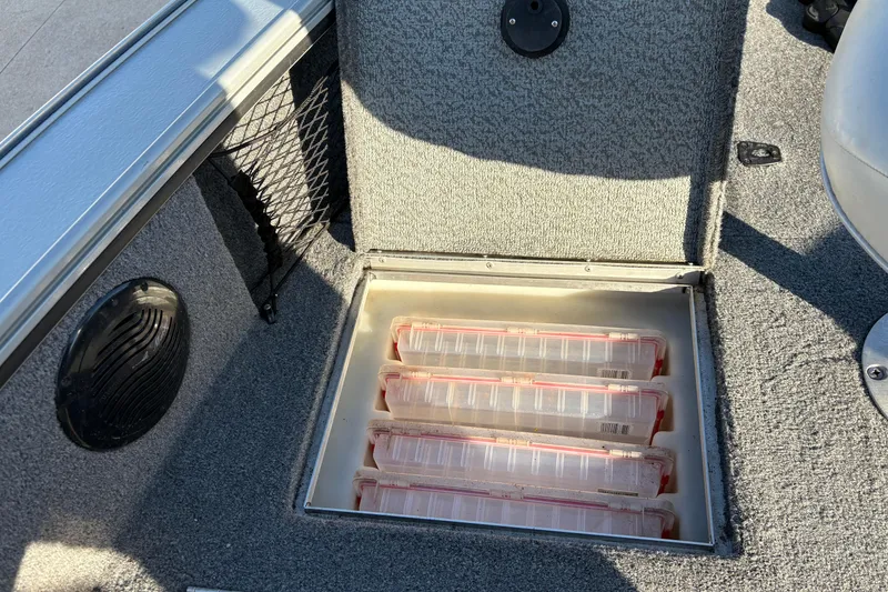 Slide: The Image of Storage compartment in a 2005 Lund 2025 Pro-V LE boat with organized tackle boxes. - 12