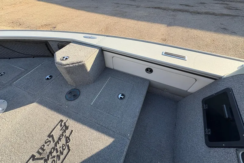 Slide: The Image of 2005 Lund 2025 Pro-V LE boat interior with storage compartments and carpeted deck. - 15