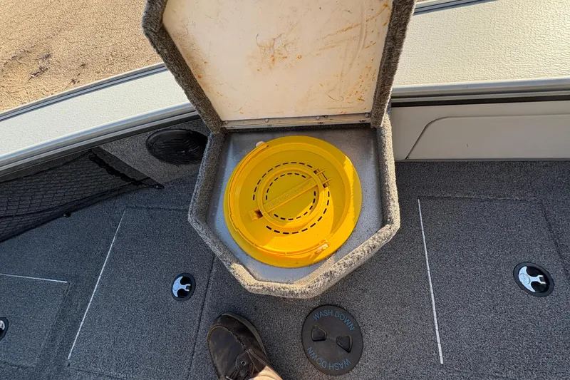 Slide: The Image of 2005 Lund 2025 Pro-V LE boat with open storage compartment and yellow container. - 16