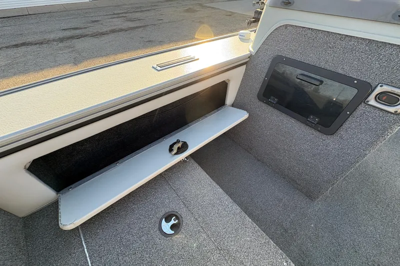 Slide: The Image of Interior of a 2005 Lund 2025 Pro-V LE boat showing storage compartment and seating area. - 18