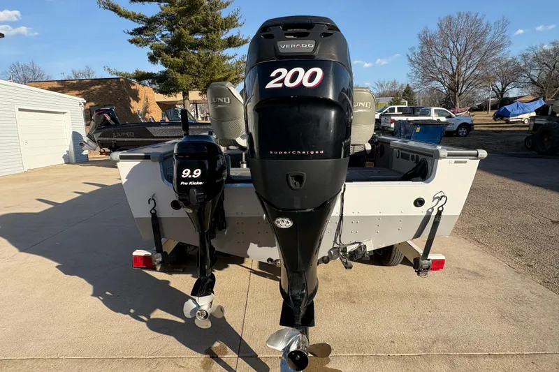 Slide: The Image of 2005 Lund 2025 Pro-V LE boat with dual outboard motors in a driveway setting. - 2