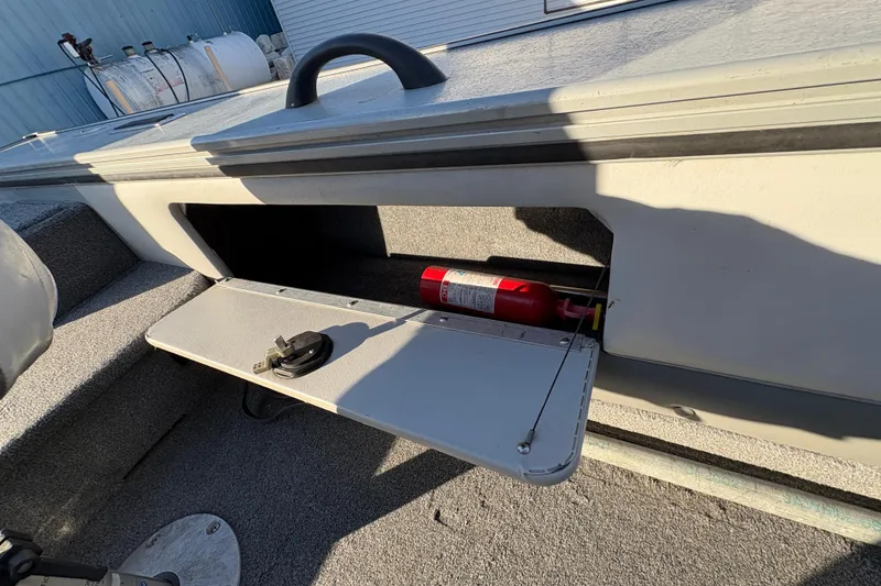 Slide: The Image of 2005 Lund 2025 Pro-V LE boat storage compartment with fire extinguisher. - 25