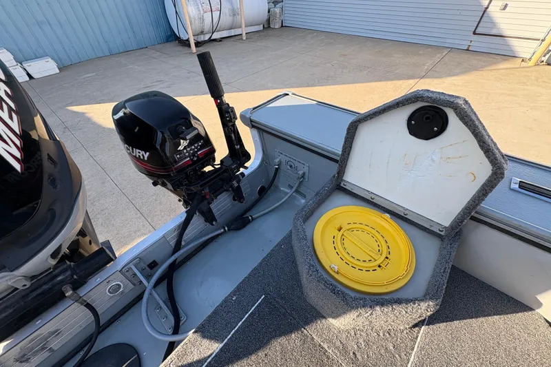 Slide: The Image of 2005 Lund 2025 Pro-V LE boat with Mercury motor and open storage compartment. - 29