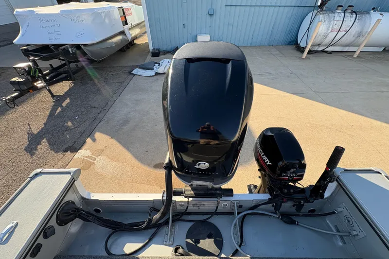 Slide: The Image of 2005 Lund 2025 Pro-V LE boat with Mercury outboard motor, parked on concrete. - 31