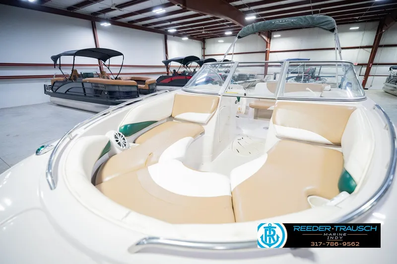 Slide: The Image of 2004 Tahoe 204 boat with beige seating in a showroom, featuring Reeder-Trausch Marine logo. - 12