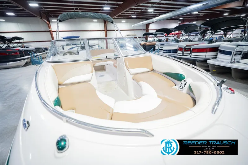 Slide: The Image of 2004 Tahoe 204 boat with tan seating in showroom, Reeder Trausch Marine logo visible. - 13
