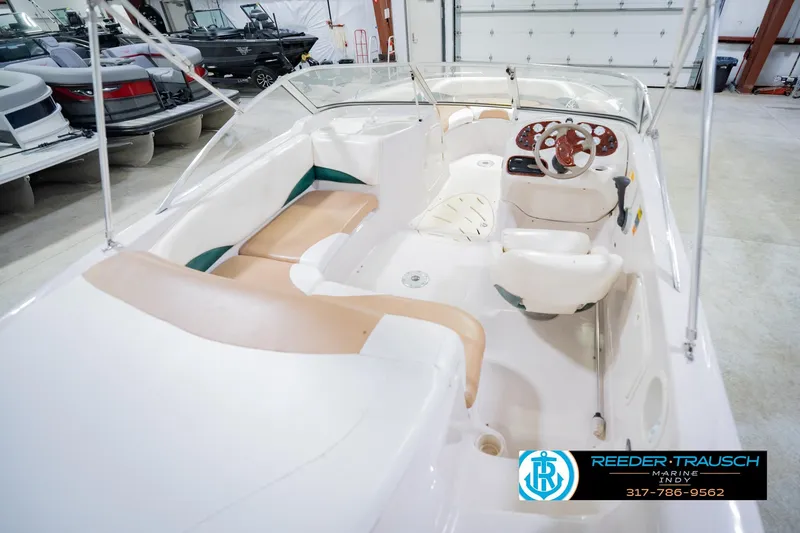 Slide: The Image of 2004 Tahoe 204 boat interior with beige seating and steering wheel in showroom. - 14