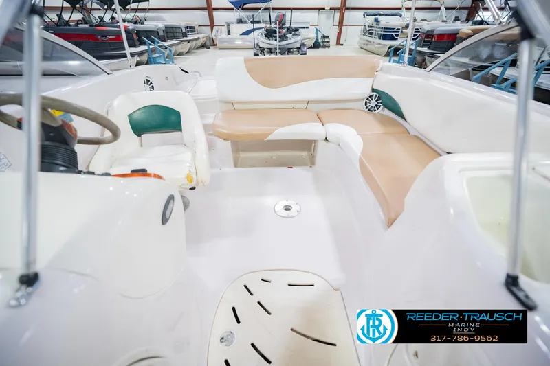 Slide: The Image of 2004 Tahoe 204 boat interior with beige seating and steering wheel in showroom. - 20