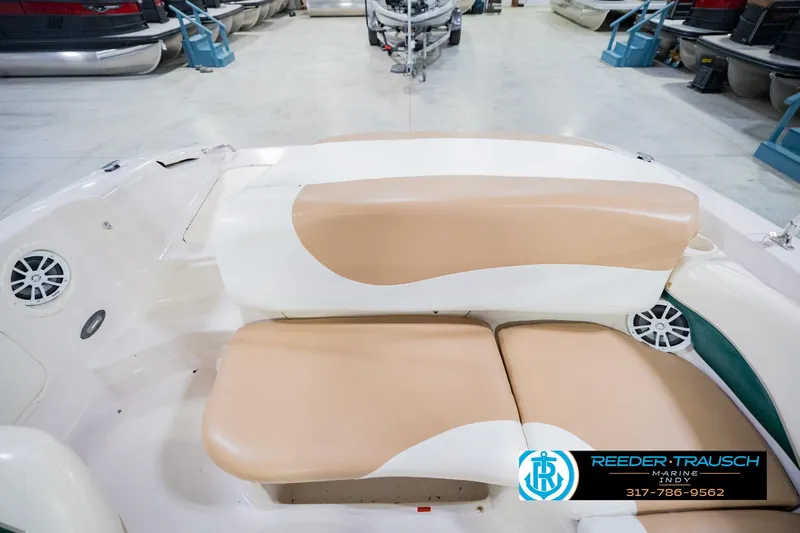 Slide: The Image of 2004 Tahoe 204 boat interior with beige and white seating in showroom. - 21