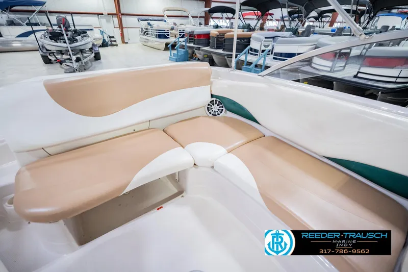 Slide: The Image of 2004 Tahoe 204 boat interior with beige and white seating in showroom. - 22