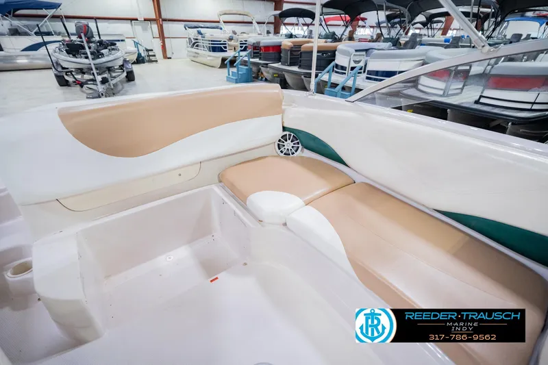 Slide: The Image of Interior of a 2004 Tahoe 204 boat with beige seating in a showroom. - 23