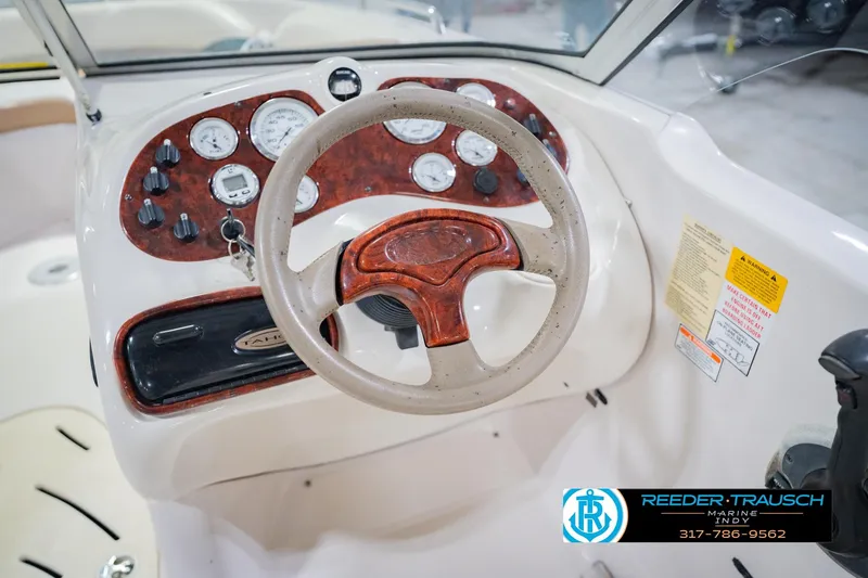 Slide: The Image of 2004 Tahoe 204 boat dashboard with wood accents and steering wheel. - 29
