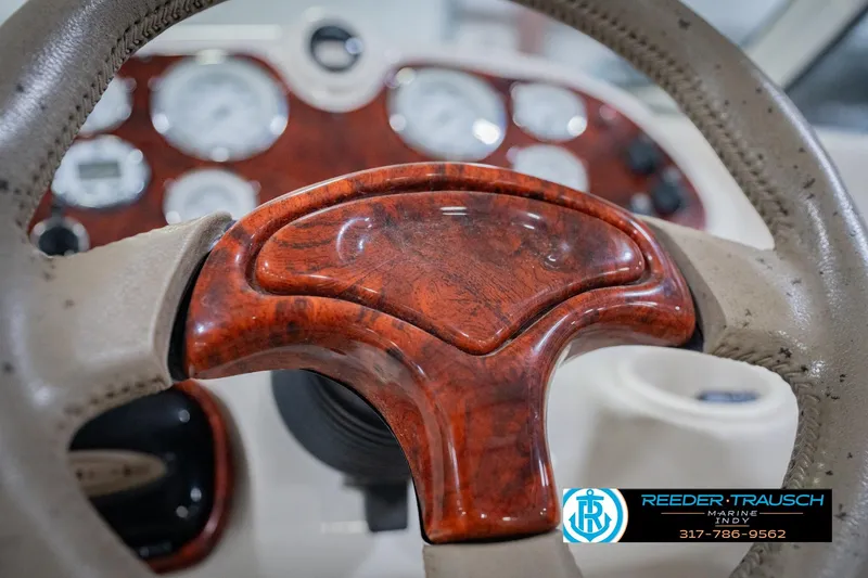 Slide: The Image of Close-up of 2004 Tahoe 204 boat steering wheel with wood finish and dashboard gauges. - 30