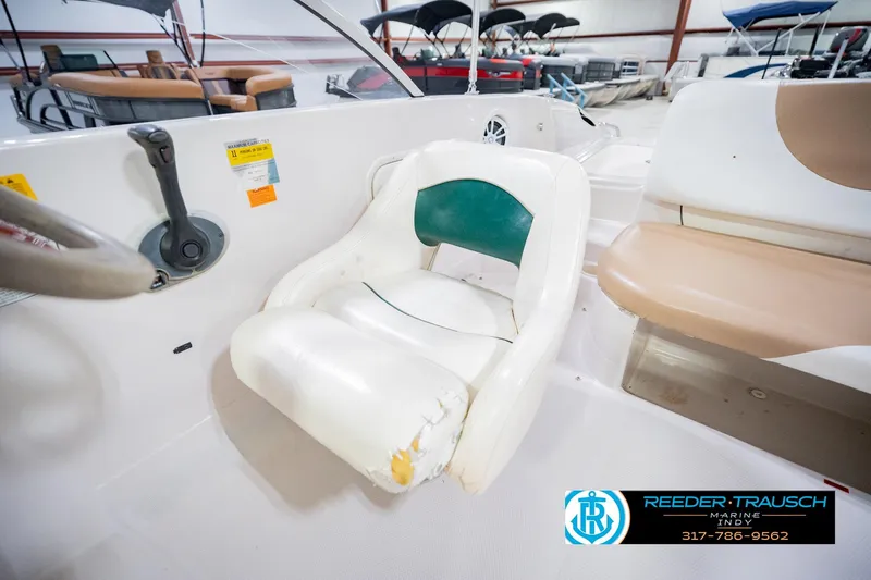 Slide: The Image of 2004 Tahoe 204 boat interior with worn white and green seating in showroom. - 35