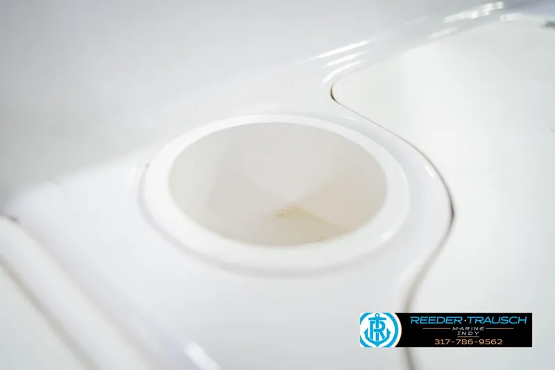 Slide: The Image of Close-up of a 2004 Tahoe 204 boat cup holder, white surface, Reeder Trausch Marine logo. - 39