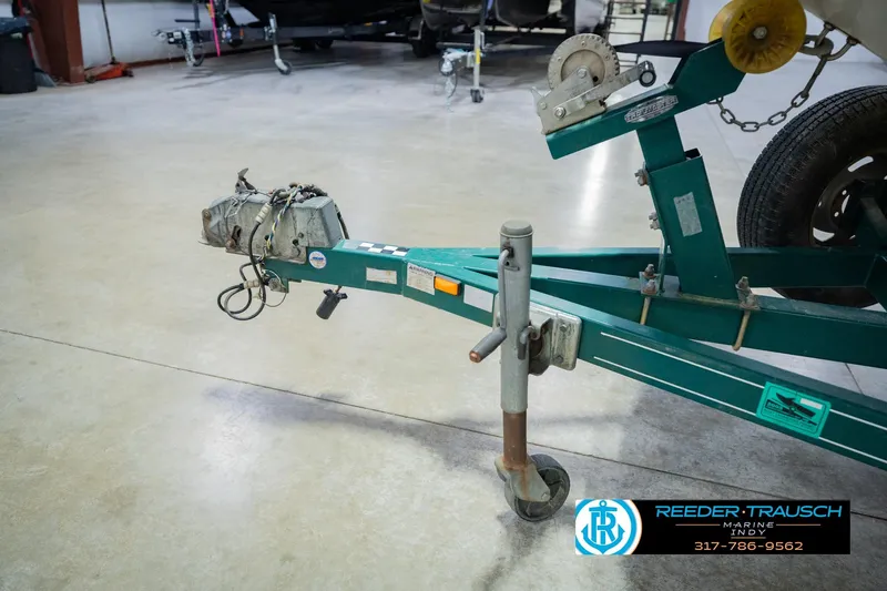 Slide: The Image of Trailer hitch of a 2004 Tahoe 204 boat, displayed in a showroom setting. - 42