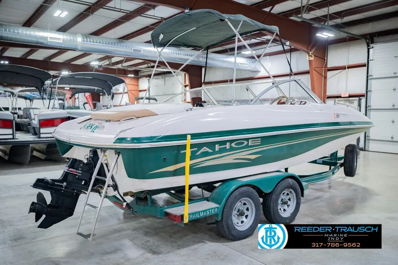 Slide: The Image of 2004 Tahoe 204 boat on trailer in indoor showroom with canopy. - 8