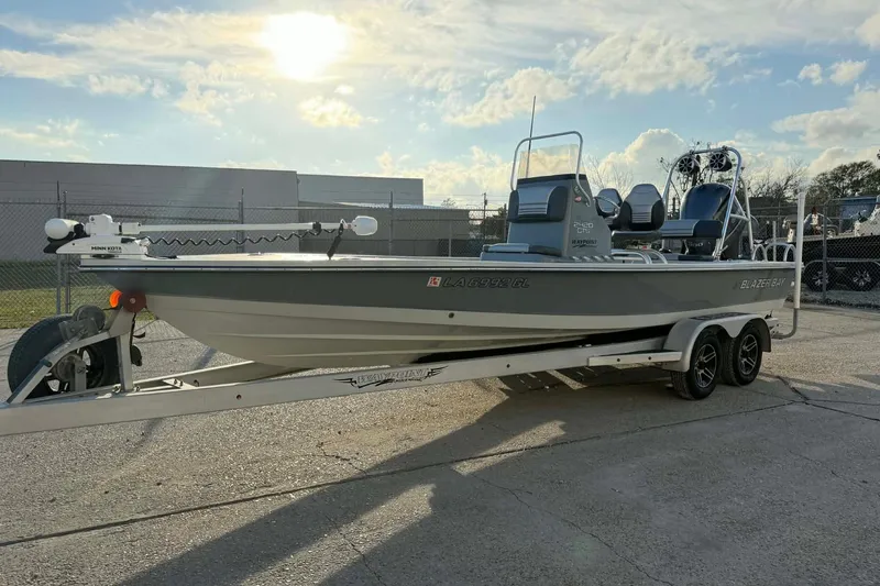 The Image of 2021 Blazer Bay 2420 boat on trailer under sunny sky. - 1