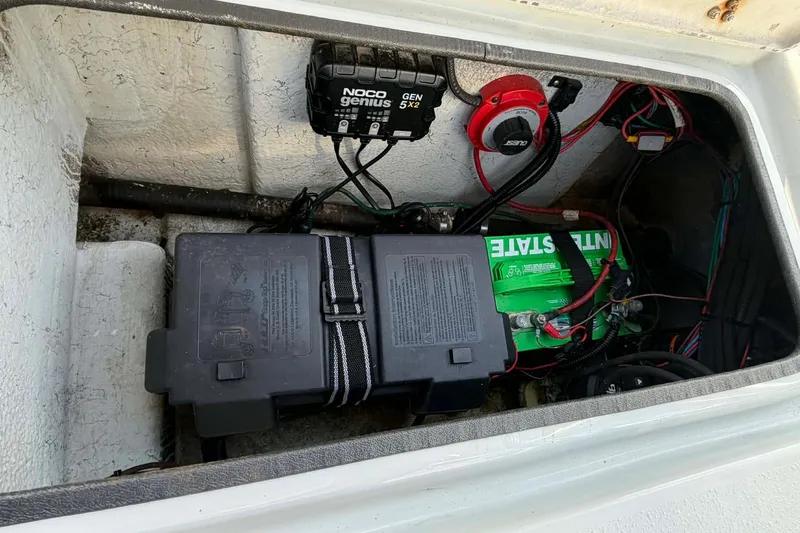 Slide: The Image of 2021 Blazer Bay 2420 boat battery compartment with NOCO Genius charger and wiring. - 14