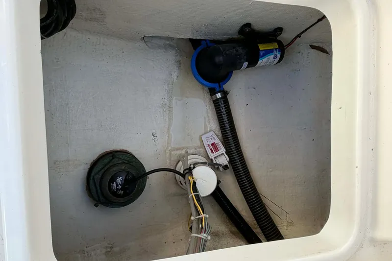 Slide: The Image of 2021 Blazer Bay 2420 boat compartment with wiring and pump system. - 20