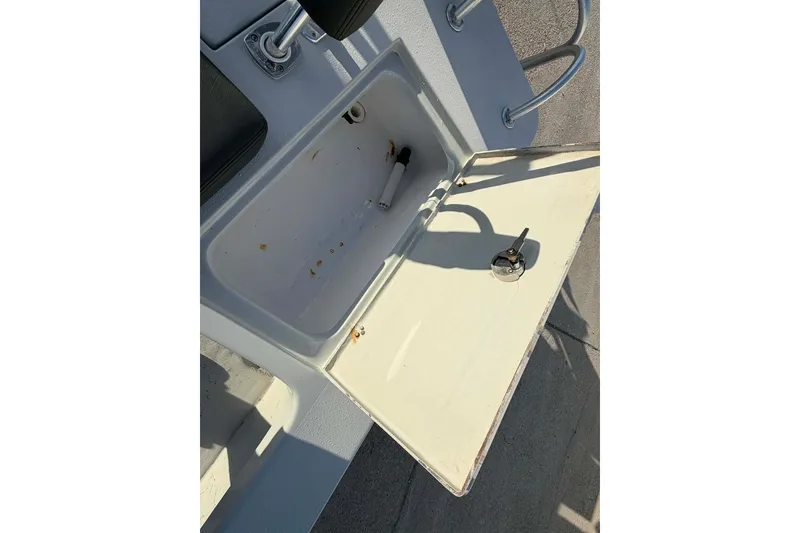 Slide: The Image of 2021 Blazer Bay 2420 boat storage compartment with open lid and visible latch. - 22