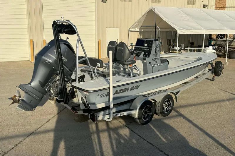 Slide: The Image of 2021 Blazer Bay 2420 boat with Yamaha engine, parked on a trailer outside a building. - 3