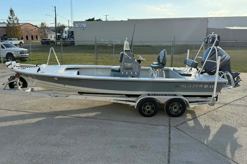 Slide: The Image of 2021 Blazer Bay 2420 boat on trailer, parked outdoors, side view. - 4