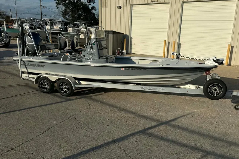 Slide: The Image of 2021 Blazer Bay 2420 boat on trailer, parked outside a warehouse. - 5