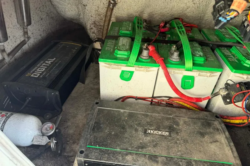 Slide: The Image of 2021 Blazer Bay 2420 boat battery compartment with multiple batteries and wiring. - 9
