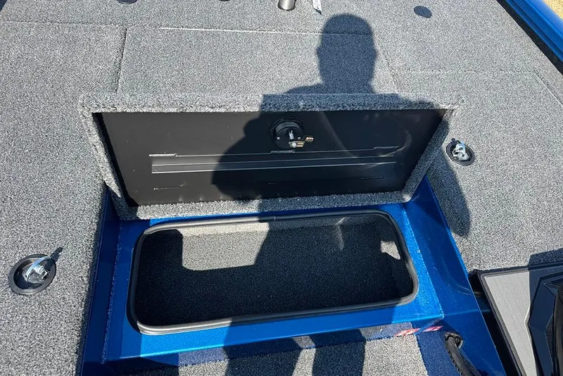 Slide: The Image of 2026 Vexus Defender 181 boat storage compartment with shadow on carpeted deck. - 12