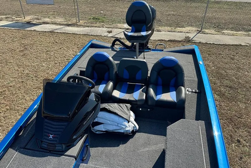 Slide: The Image of 2026 Vexus Defender 181 boat interior with blue and black seating, steering console, and storage. - 17