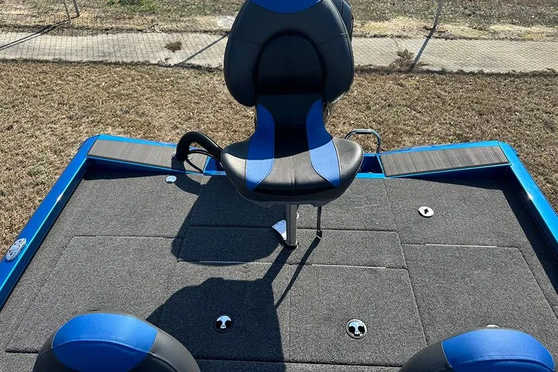 Slide: The Image of 2026 Vexus Defender 181 boat interior with blue and black seating on a carpeted deck. - 24