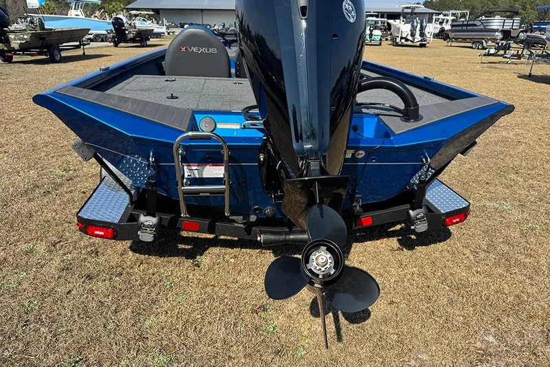 Slide: The Image of 2026 Vexus Defender 181 boat, rear view with motor and ladder, parked on grass. - 4