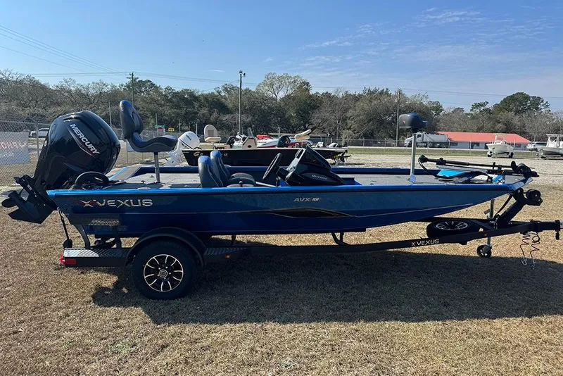 Slide: The Image of 2026 Vexus Defender 181 boat with Mercury engine on display outdoors. - 6