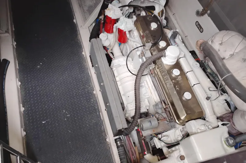 Slide: The Image of Engine compartment of a 1977 Custom International Offshore 65 boat, showcasing diesel engine components. - 101