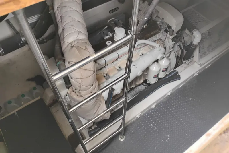Slide: The Image of Engine room of a 1977 Custom International Offshore 65 yacht, featuring a ladder and machinery. - 102
