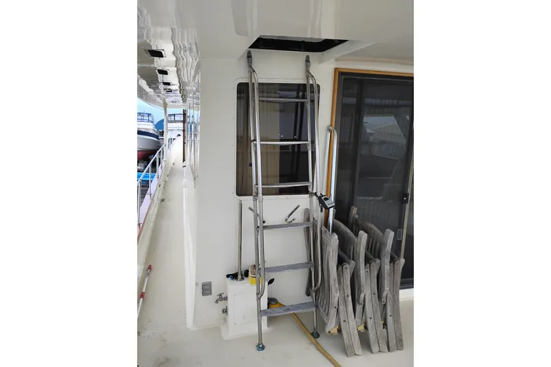 Slide: The Image of 1977 Custom International Offshore 65 yacht deck with ladder and folded chairs. - 11