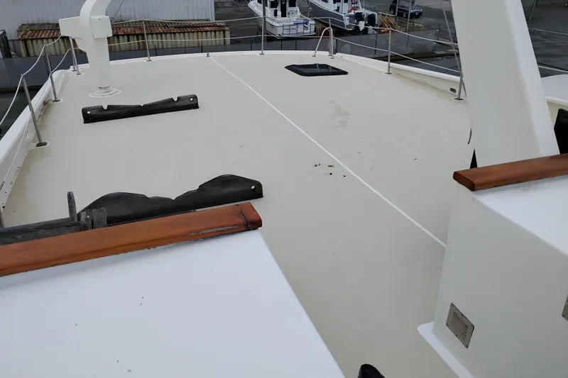 Slide: The Image of Deck of 1977 Custom International Offshore 65 yacht, featuring clean lines and wooden accents. - 12